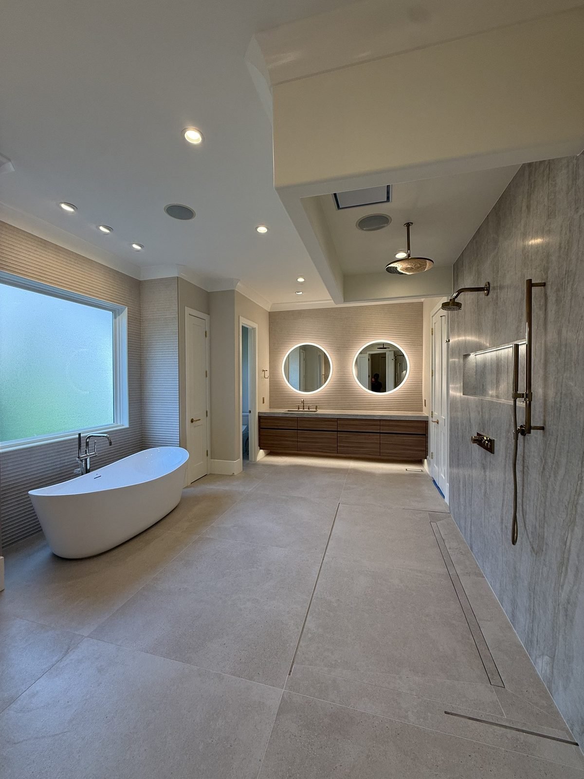 Modern master bathroom with freestanding tub, walk-in shower and floating vanity